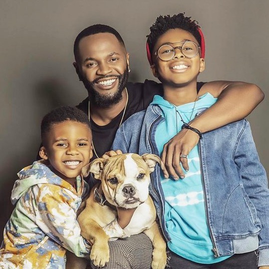 Kelvin Truitt in a black t-shirt with his sons and pet.